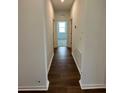 Hallway with wood floors leading to a bedroom with natural light streaming through the window at 1141 Lakeshore Breeze Pl, Kissimmee, FL 34747