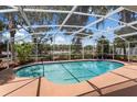 Enclosed swimming pool featuring a screened-in enclosure and a tranquil outdoor view at 1190 Pecan St, Kissimmee, FL 34744