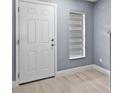 Inviting entryway with white door, wood floors, and natural light from window at 12661 Somerset Oaks St, Orlando, FL 32828