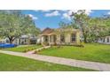 Inviting home exterior with a well-manicured lawn, trees, and a brick path, situated near the street at 1371 Lake Dr, Casselberry, FL 32707