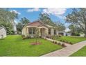 Attractive home showcasing lush green grass, mature trees, and a brick pathway leading to the front door at 1371 Lake Dr, Casselberry, FL 32707
