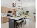 Open kitchen with island seating and a view to the backyard through sliding glass doors at 1371 Lake Dr, Casselberry, FL 32707