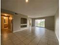 Open-concept living room with tile flooring and slider to patio; bathroom is visible at 14025 Fairway Island Dr # 335, Orlando, FL 32837
