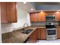 Updated kitchen with stainless steel appliances, granite counters, and wood cabinets provides a modern aesthetic at 14844 Laguna Beach Cir, Orlando, FL 32824