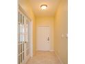 Inviting foyer with tile flooring, glass paneled doors, and neutral paint, enhancing the home's bright and welcoming ambiance at 1630 Common Way Rd # 203, Orlando, FL 32814