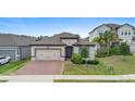 Inviting single-story home with a brick driveway and lush green lawn at 17199 Hickory Wind Dr, Clermont, FL 34711