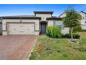 Charming single-story home with a brick driveway and well-manicured landscaping at 17199 Hickory Wind Dr, Clermont, FL 34711
