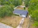 Aerial view of a well-situated home with a paved driveway and mature trees at 181 Ada Ave, Orange City, FL 32763