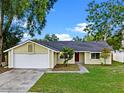 Charming single-story home featuring a red front door, a two-car garage and a well-maintained front yard at 1816 Haperon St, Apopka, FL 32703