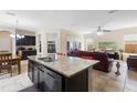 Open concept kitchen with island seating and view to living room and dining area at 2136 J Lawson Blvd, Orlando, FL 32824