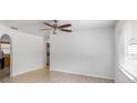 Bright living room featuring wood-look tile floors, neutral paint, a ceiling fan, and arched doorways at 2312 Ne 32Nd Pl, Ocala, FL 34479