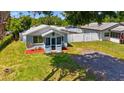 Charming home featuring a cozy, screened porch, nice landscaping, and a convenient gravel driveway at 233 E Church Ave, Longwood, FL 32750
