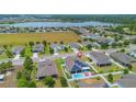 Aerial view of a home with a pool and solar panels in a lakeside community at 2518 Hayden Valley St, Apopka, FL 32703