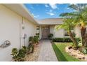 Pathway leads to a neutral-colored front door, complemented by lush landscaping and a well-kept lawn at 2640 Shelby Ruth Pl, St Cloud, FL 34769