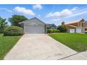 Driveway and exterior of home with well-maintained landscaping and mature trees in the front yard at 2681 Debany Rd, Kissimmee, FL 34744