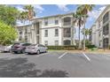 Condominium building featuring balconies, lush greenery, and designated parking area at 2717 Maitland Crossing # 207, Orlando, FL 32810