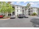 Condominium building exterior showcasing balconies, lush landscaping, and ample parking at 2717 Maitland Crossing # 207, Orlando, FL 32810