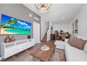 Chic living area with open layout, featuring sleek decor, a staircase, and seamless transition to dining and kitchen at 296 Famagusta Dr, Davenport, FL 33896