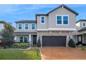 Charming two-story home with stone accents, manicured landscaping, and a brick driveway at 3310 Stonewyck St, Orlando, FL 32824