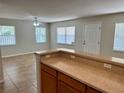 Open living area with a ceiling fan, tile flooring, plenty of natural light, and access to the kitchen at 404 S Salisbury Ave, Deland, FL 32720