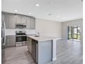Modern kitchen features stainless steel appliances, a center island, and stylish gray cabinets at 4353 Campsite Loop, Orlando, FL 32824