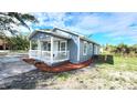 Side view of a charming blue home with a covered porch and neatly mulched landscaping at 509 Grove Ave, Orlando, FL 32805