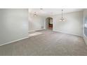 Spacious carpeted living room featuring a neutral color palette and arched doorway at 5236 Shale Ridge Trl, Orlando, FL 32818