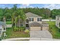 Inviting two-story home featuring a stone facade, three-car garage, and mature landscaping in a suburban setting at 5525 Oakworth Pl, Sanford, FL 32773