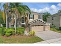 Charming home boasting a stone-accented facade, three-car garage, lush landscaping, and mature palm trees at 5525 Oakworth Pl, Sanford, FL 32773