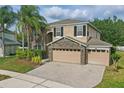 Attractive two-story home featuring stone details, a three-car garage, and a well-maintained front yard with palm trees at 5525 Oakworth Pl, Sanford, FL 32773