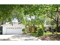 Inviting home showcasing a well-kept front yard, mature trees, and a convenient two-car garage at 6105 Lost Tree Court, Orlando, FL 32808