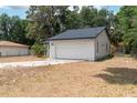 Charming single-story home featuring a white exterior, a two-car garage, and well-maintained landscaping at 6345 Hatcher Rd, Lakeland, FL 33811