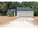 Charming single-story home featuring a white exterior, a two-car garage, and well-maintained landscaping at 6345 Hatcher Rd, Lakeland, FL 33811