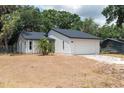 Charming single-story home featuring a white exterior, a two-car garage, and well-maintained landscaping at 6345 Hatcher Rd, Lakeland, FL 33811