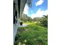 Exterior shot of the backyard featuring a small patio and an expansive grassy area at 732 Trenton Rd, Lakeland, FL 33815