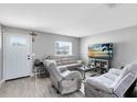 Bright living room with wood-look tile, neutral walls, comfortable seating, and a front door at 7741 Pine Hollow Ct, Orlando, FL 32822