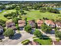 Stunning aerial view of a home nestled in a golf course community with lake views and beautiful landscaping at 8150 Prestbury Dr, Orlando, FL 32832