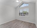 Bright bedroom featuring wood floors, high ceilings, and a large window for natural light at 831 Islander Ave, Orlando, FL 32825