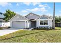 Charming single-story home with gray exterior, well-maintained lawn, and attached two-car garage at 831 Islander Ave, Orlando, FL 32825