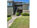Charming two-story condo with lush green lawn, exterior staircase, and nice landscaping at 5964 Peregrine Ave # C02, Orlando, FL 32819