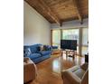 Bright living room featuring hardwood floors, wood beamed ceilings and a large window at 5964 Peregrine Ave # C02, Orlando, FL 32819