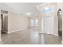 Spacious living room with tiled floors, high ceilings, and abundant natural light from the large front windows at 10 Alicante Ct, Kissimmee, FL 34758