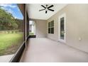 Spacious screened patio with ceiling fan, providing a relaxing outdoor living area overlooking the backyard at 11255 Se 170Th Pl, Summerfield, FL 34491