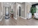 Elegant foyer with wood-look tile, tray ceiling, decorative mirror and table, plus a stylish front door at 13139 Stanthorne Ave, Orlando, FL 32832