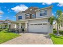 Charming two-story home with stone accents, covered porch, and a paved driveway leading to a two car garage at 13139 Stanthorne Ave, Orlando, FL 32832