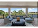 Covered patio with lake view, stylish outdoor seating, and brick flooring, perfect for entertaining at 13139 Stanthorne Ave, Orlando, FL 32832