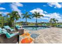 Backyard oasis with a pool surrounded by lounge seating, palm trees, and a fire pit at 13139 Stanthorne Ave, Orlando, FL 32832