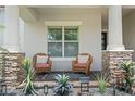 Cozy front porch with stone columns, wicker chairs, and decorative plants offers a relaxing outdoor space at 13139 Stanthorne Ave, Orlando, FL 32832