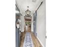 Foyer features wood floors, a decorative rug, statement lighting, and a barn door at 1330 W Harvard St, Orlando, FL 32804
