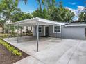 Gray single-story home featuring a covered parking area and beautiful landscaping at 1414 Beaver Pl, Orlando, FL 32806